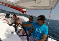 skipper e ragazza behind ruota del timone di trimarano  neel 45 yacht 2
